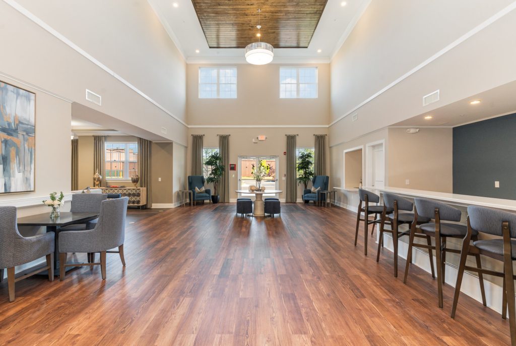 A bright and airy community lounge featuring high ceilings, elegant furnishings, and ample natural light. Ideal for socializing and relaxation.