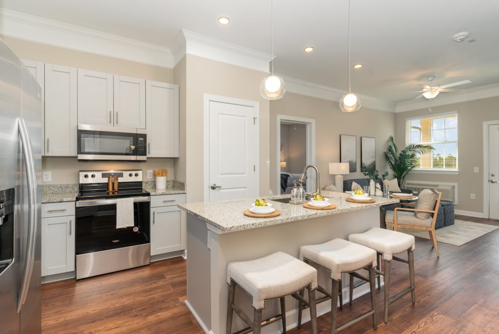 Modern kitchen with granite countertops, stainless steel appliances, and a breakfast bar. Open layout connects seamlessly to the living area.