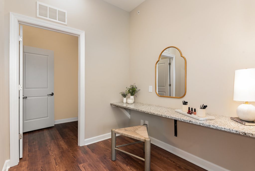 Charming vanity area featuring a granite countertop, large mirror, and tasteful decor. Perfect for personal grooming and relaxation.