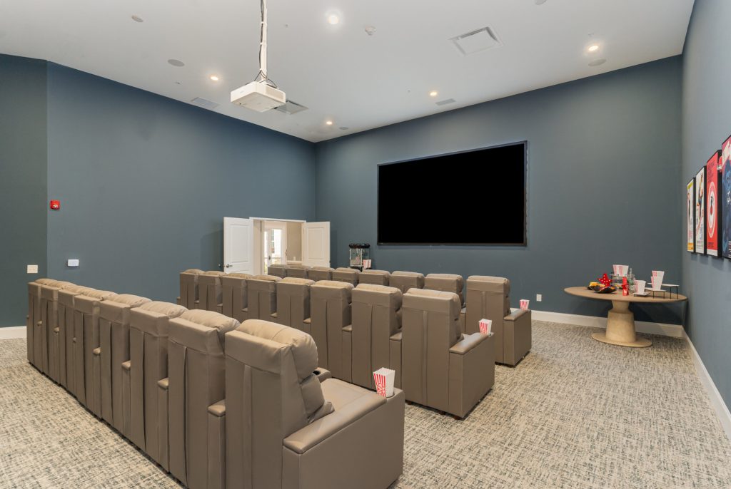 Spacious home theater room with comfortable reclining chairs and a large screen for an immersive movie-watching experience. Perfect for group entertainment.