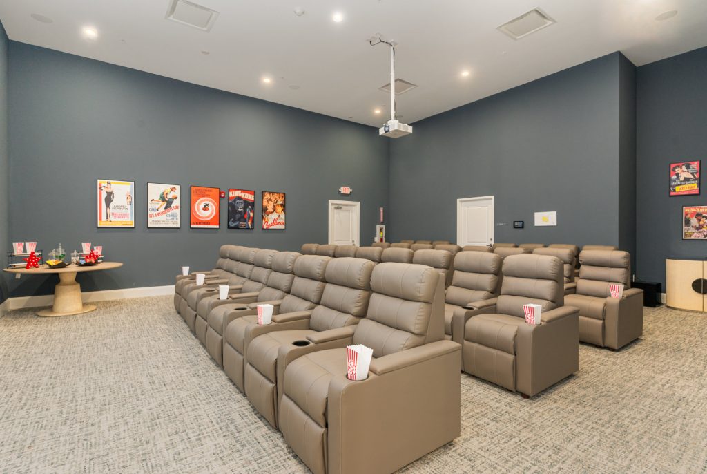 Comfortable home theater room with plush reclining chairs, a large screen, and elegant decor. Ideal for private movie nights and entertainment.