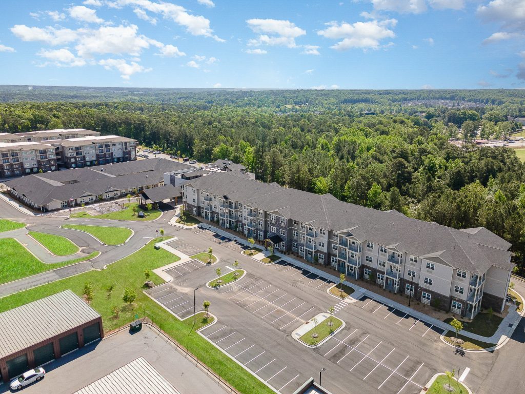 unning aerial view of Kingswood Reserve, a modern residential complex surrounded by lush greenery. Features spacious parking areas and well-maintained landscaping.